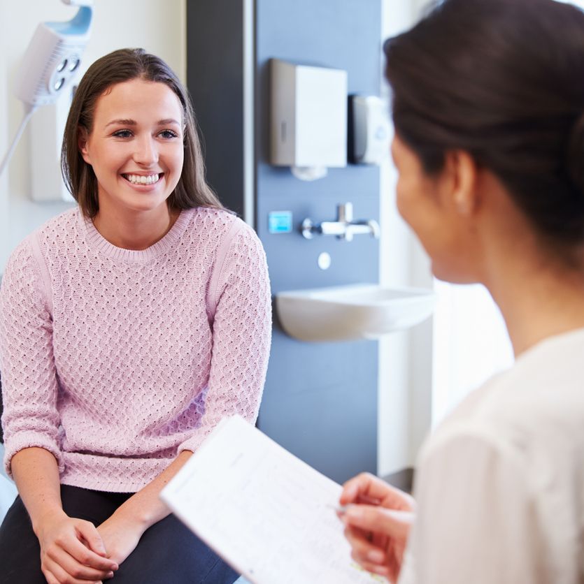 Female Patient And Doctor Have Consultation In Hospital Room