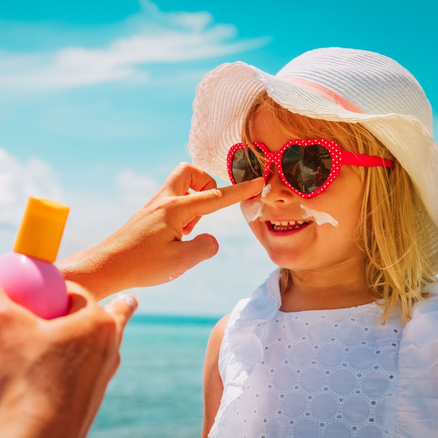 sun protection - mother put sunblock cream on little daughter face