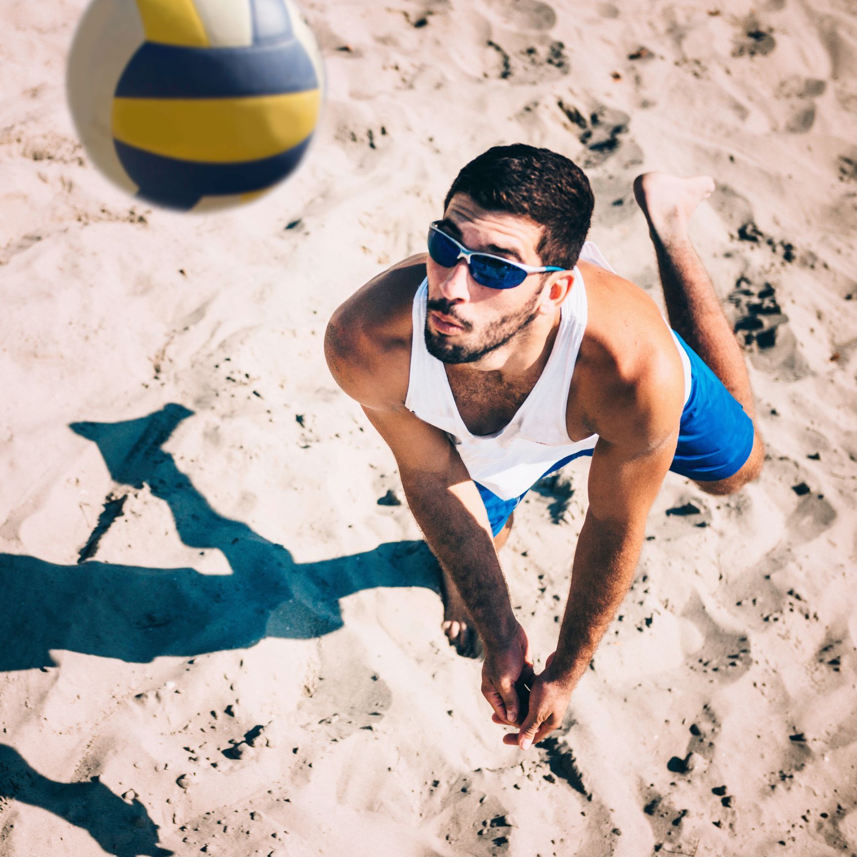 Beach volleyball player receiving the ball, action shot